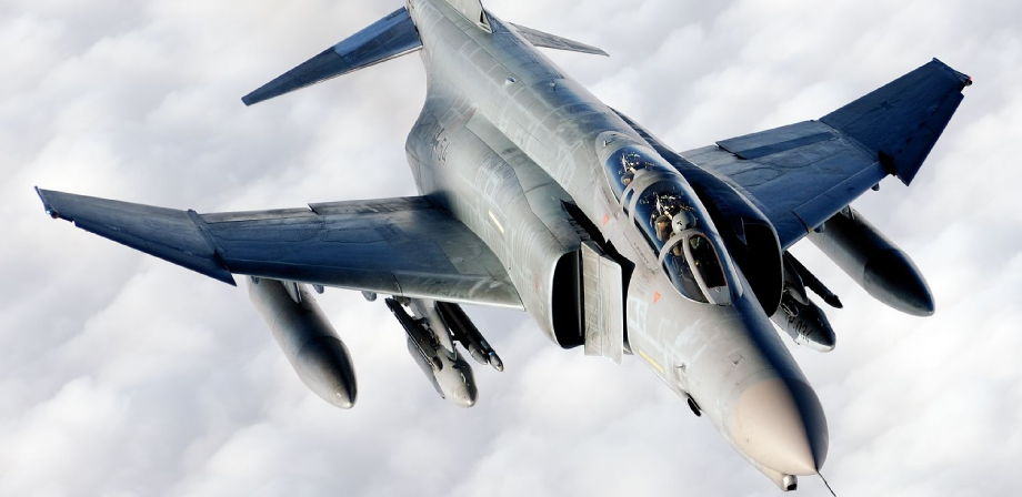 F-4 Phantom II fighter jet in flight above the clouds